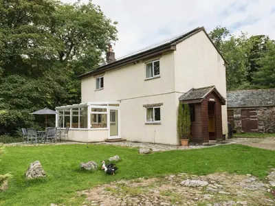 a house with a yard with some animals in the yard at Beck Cottage in Ennerdale Bridge