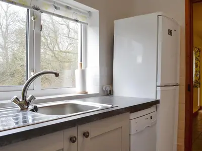 a kitchen with a sink and a refrigerator at Beck Cottage in Ennerdale Bridge