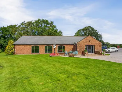 a brick building with a lawn in front of it at Halls Bank Farm in Plumbland
