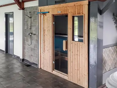 a bathroom with a shower and a wooden door at Berwyn Bank in Gilcrux