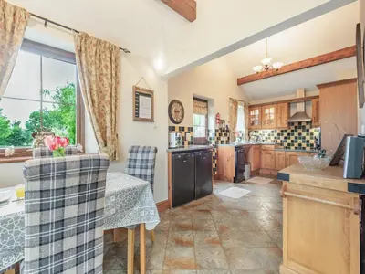 a kitchen with a table and chairs in a room at Beckside in Gilcrux