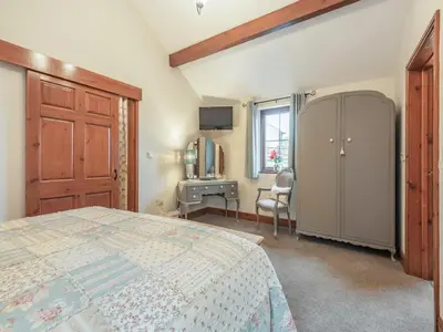 a bedroom with a bed and a desk and a window at Beckside in Gilcrux