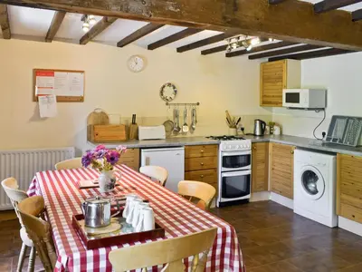 a kitchen with a table with a red and white table cloth at The Corn Mill in Branthwaite