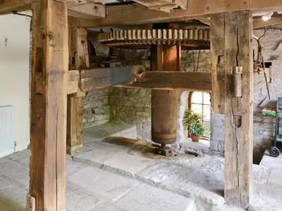 a wooden table in a room with a stone fireplace at The Corn Mill in Branthwaite