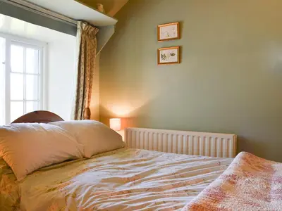 a bedroom with a bed and a window at Birkerthwaite Cottage-W41479 in Eskdale