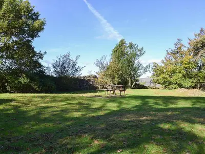 a picnic table in the middle of a field at Birkerthwaite Cottage-W41479 in Eskdale