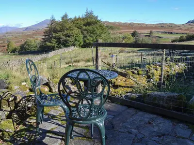 a pair of chairs and a table on a patio at Birkerthwaire Stable-W41477 in Eskdale