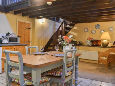 a kitchen and dining room with a wooden table and chairs at Birkerthwaite Barn-W41478 in Eskdale