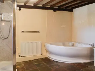 a large white tub in a bathroom with a shower at Birkerthwaite Barn-W41478 in Eskdale