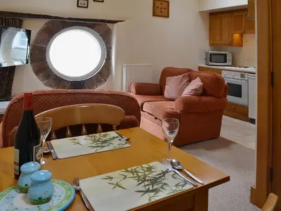 a living room with a table and a couch at Grooms Room in Thirlmere