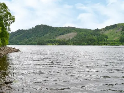a large body of water with mountains in the background at Grooms Room in Thirlmere