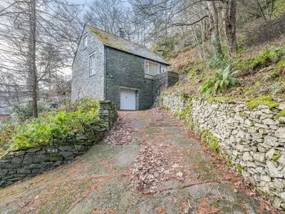 a stone building with a white door on a stone wall at Galena in Glenridding