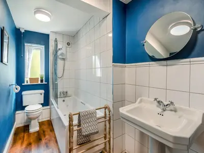 a bathroom with blue walls and a sink and a toilet at Stybarrow View Cottage in Glenridding
