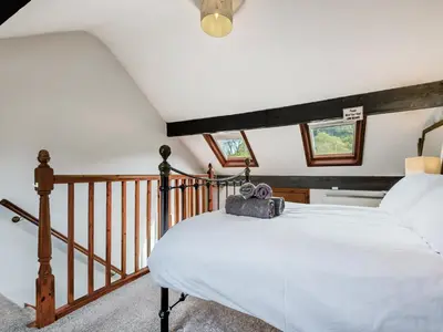 a bedroom with a bed with a suitcase on it at Stybarrow View Cottage in Glenridding