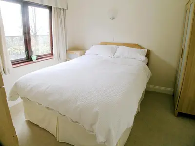 a bedroom with a large white bed with a window at Bank End in Glenridding