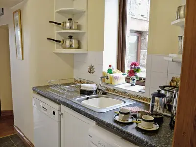 a kitchen with a sink and a counter top at Stonefold Cottage in Waberthwaite