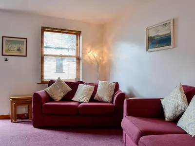 a living room with a red couch and a chair at Inglewood - 15288 in Keswick