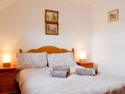 a bedroom with a white bed with two lamps at Inglewood - 15288 in Keswick