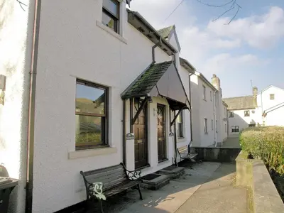 a white building with a bench in front of it at Glenwood - 18630 in Keswick