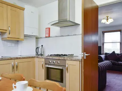 a kitchen with a stove top oven next to a living room at Glenwood - 18630 in Keswick