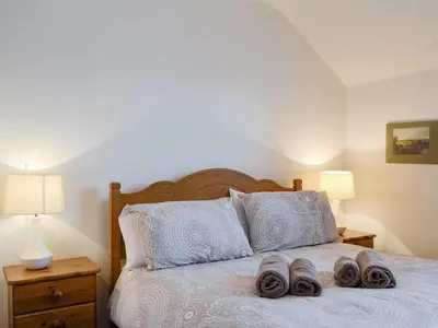 a bedroom with a bed with two slippers on it at Glenwood - 18630 in Keswick