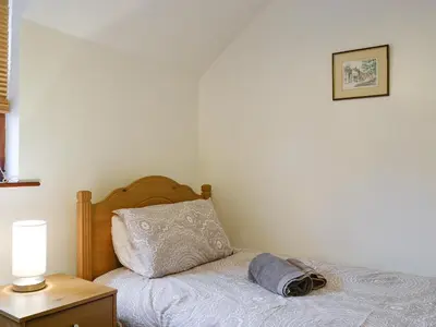 a bedroom with a bed with a pillow and a lamp at Glenwood - 18630 in Keswick
