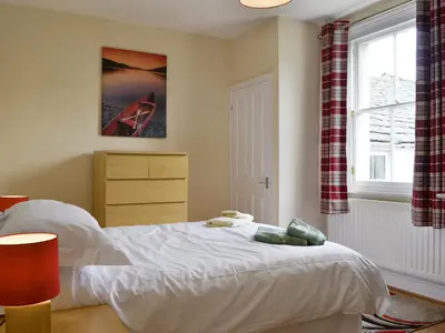 a bedroom with a white bed and a window at Skiddaw View in Keswick