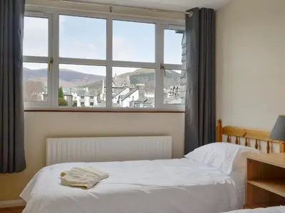 a bedroom with a bed and a large window at Skiddaw View in Keswick