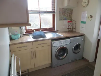 a kitchen with a washing machine and a sink at Apple Tree Cottage in Threlkeld