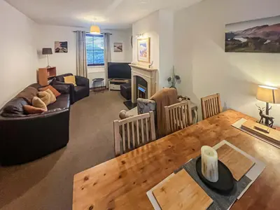a living room with a couch and a table at Apple Tree Cottage in Threlkeld
