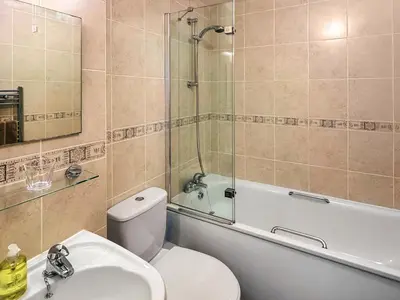 a bathroom with a toilet and a sink and a bath tub at Flat 4 in Keswick