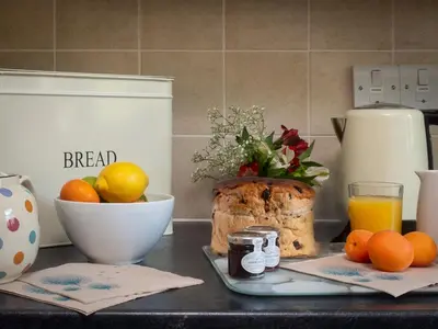 a kitchen counter with a plate of bread and oranges at Flat 4 in Keswick