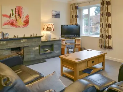 a living room with a fireplace and a tv at Quiet Ways in Portinscale