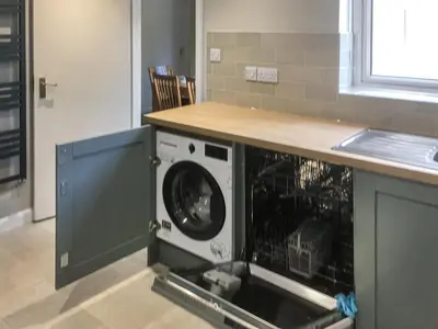 a washing machine under a counter in a kitchen at Quiet Ways in Portinscale