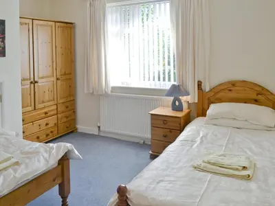 a bedroom with a bed and a dresser and a window at Quiet Ways in Portinscale