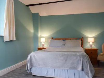 a bedroom with a bed with blue walls and two lamps at Lowther - Np2801 in Dockray