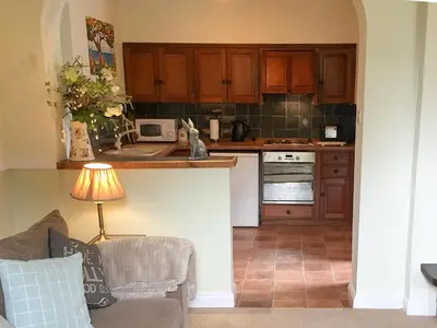 a kitchen with wooden cabinets and a couch in a room at Little Beck in Troutbeck