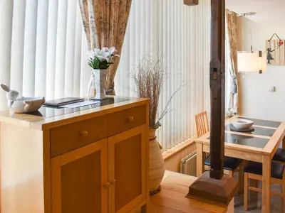 a room with a table with a vase on top of a wooden cabinet at The Carriage House in Watermillock
