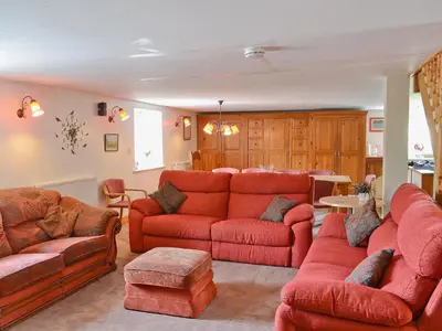 a living room with red couches and a table at The Barn in Waberthwaite