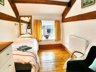 a bedroom with a bed and a window in a room at The Barn in Waberthwaite
