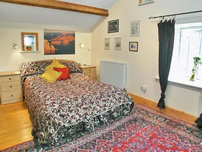 a bedroom with a bed and a window at The Barn in Waberthwaite