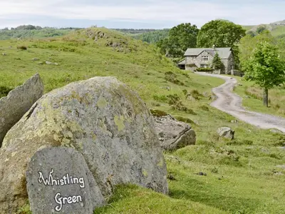 a rock with the words wrinkling green on it on a hill at Whistling Green in Ulpha
