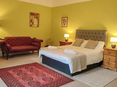 a bedroom with a large bed and a couch at Whitehall Pele Tower in Mealsgate