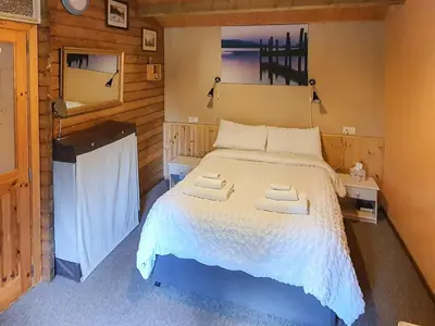 a bedroom with a bed with two towels on it at Hedgehog Meadows in Waverton