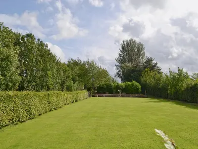 a large grassy yard with hedges and a sky at Hedgehog Meadows in Waverton
