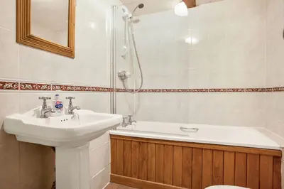 a bathroom with a sink and a shower at The Coppermines Mountain Cottages - Carpenters, Millrace, Pelton Wheel, Sleeps 14 in Coniston