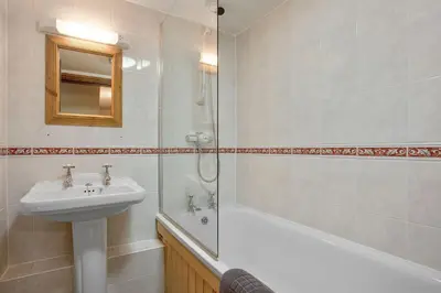 a bathroom with a sink and a toilet and a shower at The Coppermines Mountain Cottages - Sawyers, Carpenters, Pelton Wheel, Sleeps 18 in Coniston