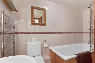 a bathroom with a toilet and a sink and a mirror at The Coppermines Mountain Cottages - Sawyers, Carpenters, Pelton Wheel, Sleeps 18 in Coniston