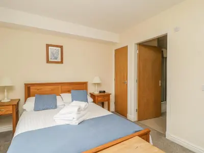 a bedroom with a bed with blue and white sheets at Whitbarrow 24 in Penrith