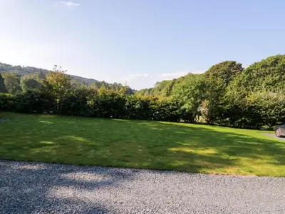 a grassy field with trees in the background at Dalegarth Hall Farm Cottage 2 in Holmrook